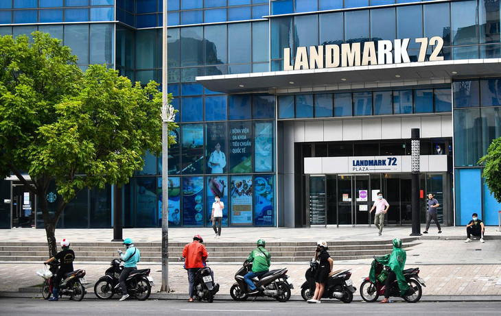 Vào thời điểm chưa giãn cách xã hội, rất đông shipper đỗ xe dọc lề đường Phạm Hùng, chân tòa nhà Land Mark 72 vào buổi trưa và chiều. Tuy nhiên, hiện nay khu vực này vắng hơn, chỉ lác đác hơn chục người đang chờ giao đồ ăn.