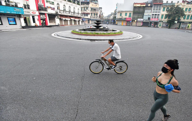 Người dân chạy bộ, đạp xe qua khu vực quảng trường Đông Kinh Nghĩa Thục ở quận Hoàn Kiếm.