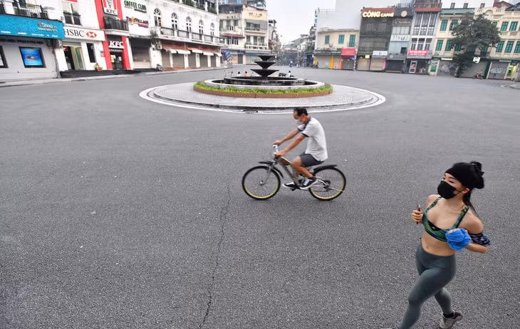 Người dân chạy bộ, đạp xe qua khu vực quảng trường Đông Kinh Nghĩa Thục ở quận Hoàn Kiếm.