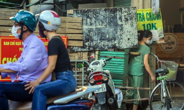 Người dân luồn lách qua rào chắn cứng để di chuyển.