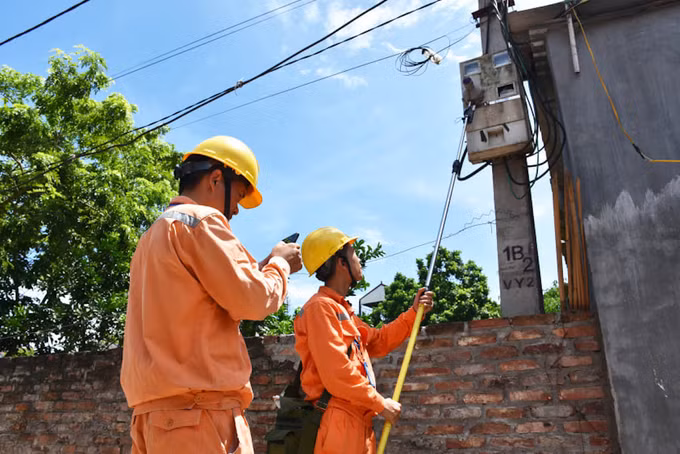 Công nhân Công ty Điện lực Mê Linh ghi chỉ số công tơ điện tại huyện Mê Linh (Hà Nội)
