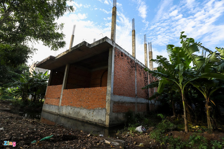 Nằm cách đó không xa, nhiều căn nhà xây dựng dở dang, xung quanh là cây cối um tùm, nước mưa tù đọng lâu ngày, tạo điều kiện cho ruồi muỗi sinh sôi.