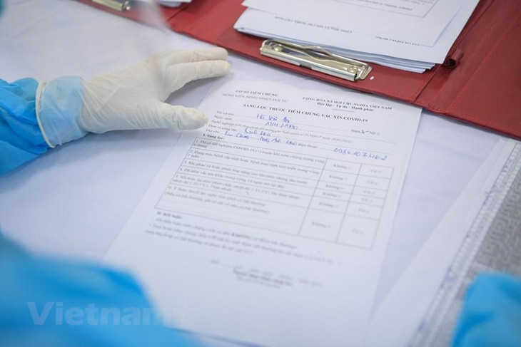 Sau khi tiêm, người được tiêm phải ở lại theo dõi 30 phút và theo tiếp tục theo dõi tại nhà trong 24h. Đối với trường hợp cấp cứu phải theo dõi tiếp 24 giờ tại bệnh viện, cơ sở y tế. Ảnh: Vietnam+