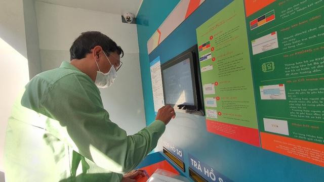 Người dân sử dụng máy tiếp nhận - trả hồ sơ trong ngày đầu vận hành