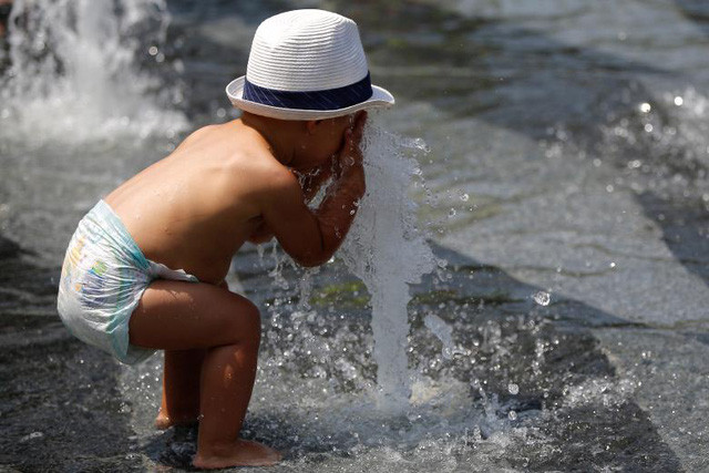  Một em bé chơi ở đài phun nước để “giải nhiệt” trong đợt nắng nóng bất thường ở Nantes, Pháp (Ảnh: Reuters) 