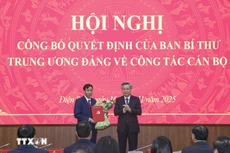 Phó Trưởng Ban Tổ chức Trung ương Nguyễn Quang Dương trao Quyết định và tặng hoa chúc mừng ông Lê Văn Lương. (Ảnh: Xuân Tư/TTXVN)