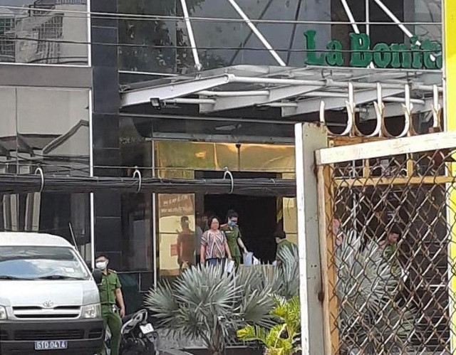 Bà Vũ Bảo Trinh đi ra cùng công an