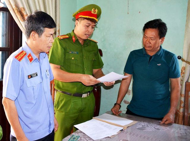 Lực lượng chức năng tống đạt các quyết định với đối tượng Lê Tự Trung. Ảnh CTV