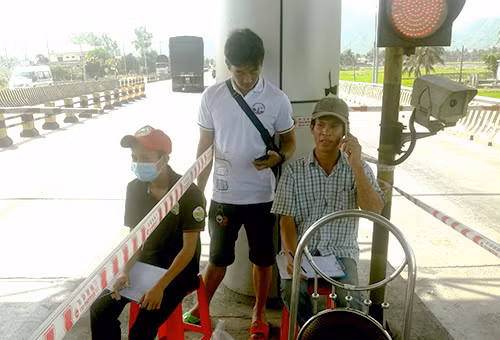 Người dân đếm từng lượt xe qua trạm thu phí Ninh Lộc. 