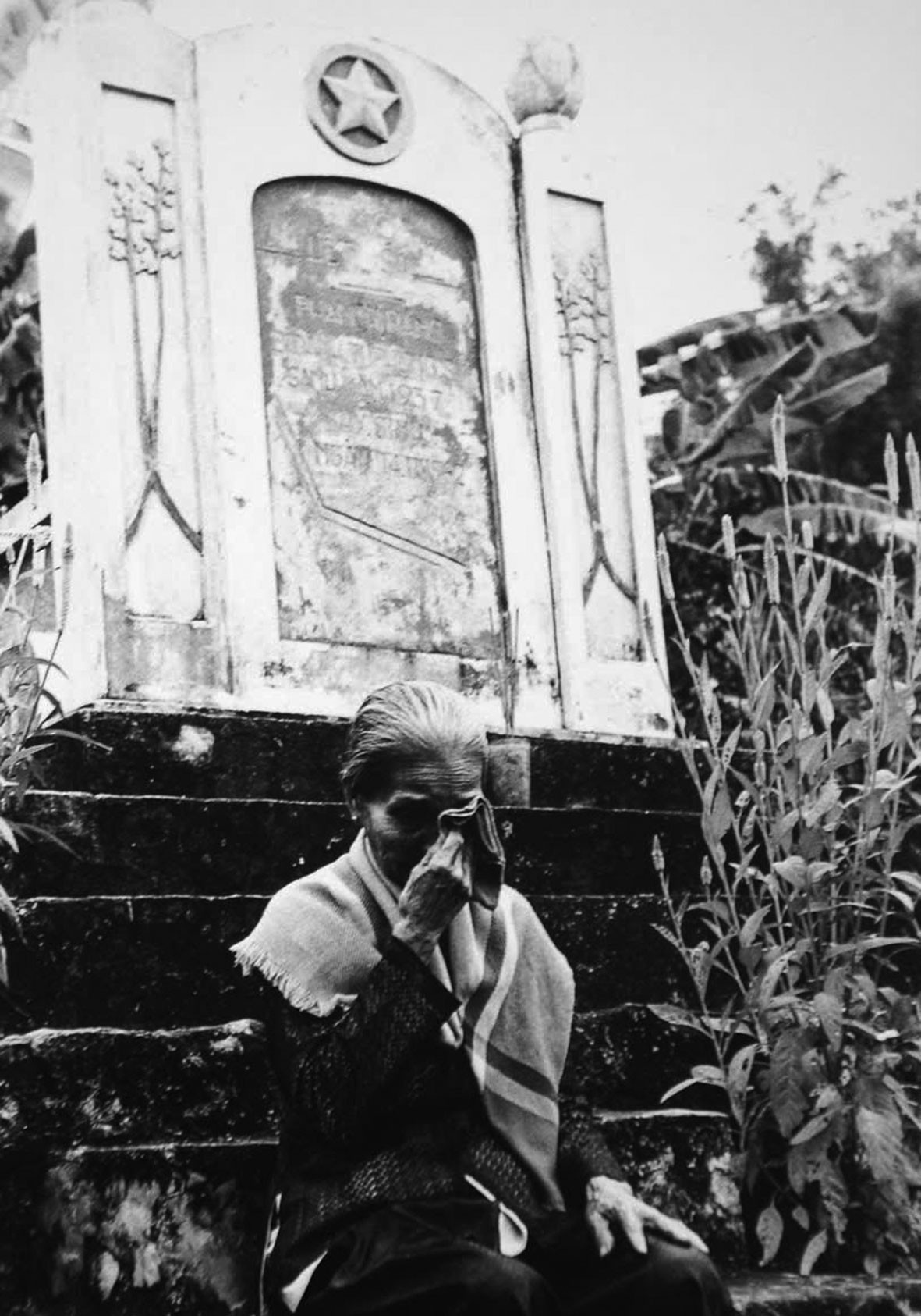 Má Bảy Hương (mẹ chị Sứ) bên mộ Chị. Bức ảnh năm 1983, khi nhà báo Trần Mai Hưởng trở lại Hòn Đất