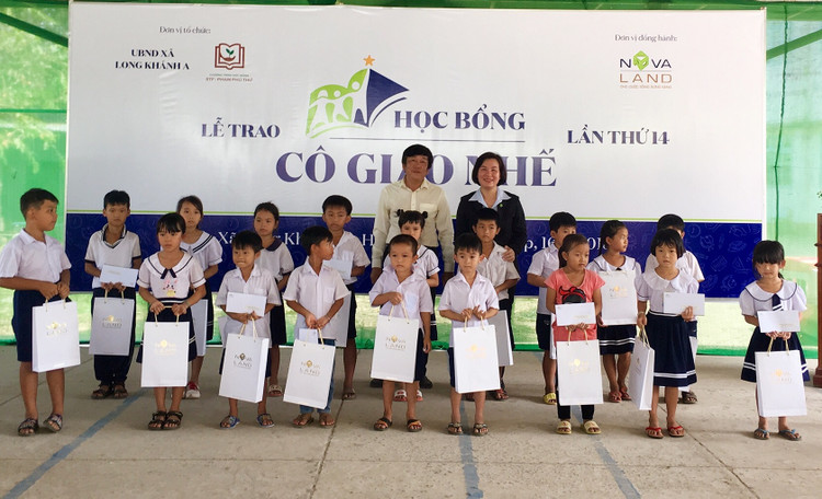 Đại diện Tập đoàn Novaland và lãnh đạo địa phương trao học bổng đến các em học sinh hiếu học 