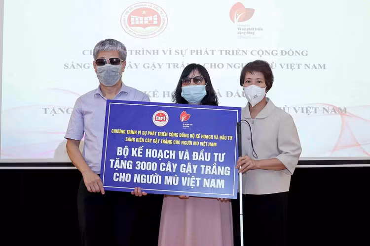 Thứ trưởng Nguyễn Thị Bích Ngọc (bên phải) trao biển và gậy tượng trưng cho Hội người mù Việt Nam