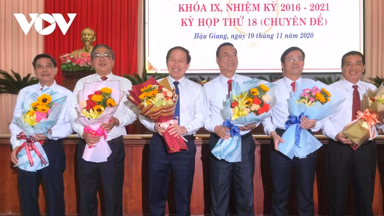 Ông Trần Văn Huyến (thứ hai từ phải qua) và ông Đồng Văn Thanh (bìa trái) nhận hoa chúc mừng.