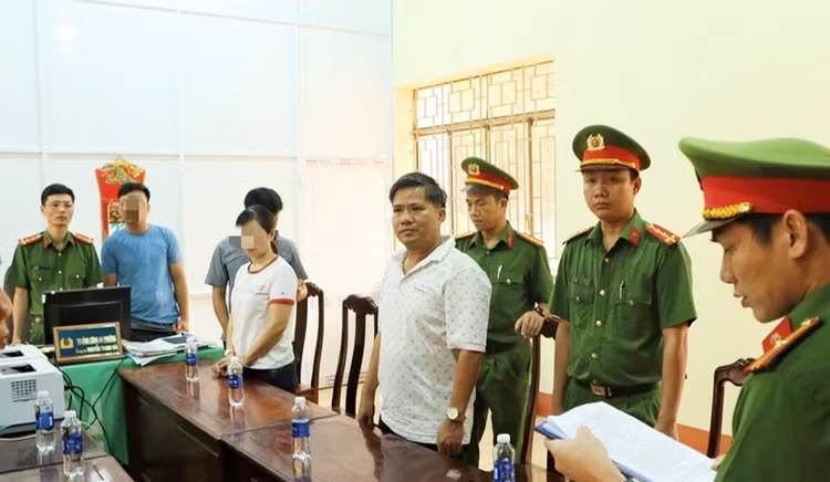 Cơ quan Công an thực hiện lệnh khởi tố bị can và bắt tạm giam đối với Nguyễn Hữu Hóa (áo trắng, bên phải)